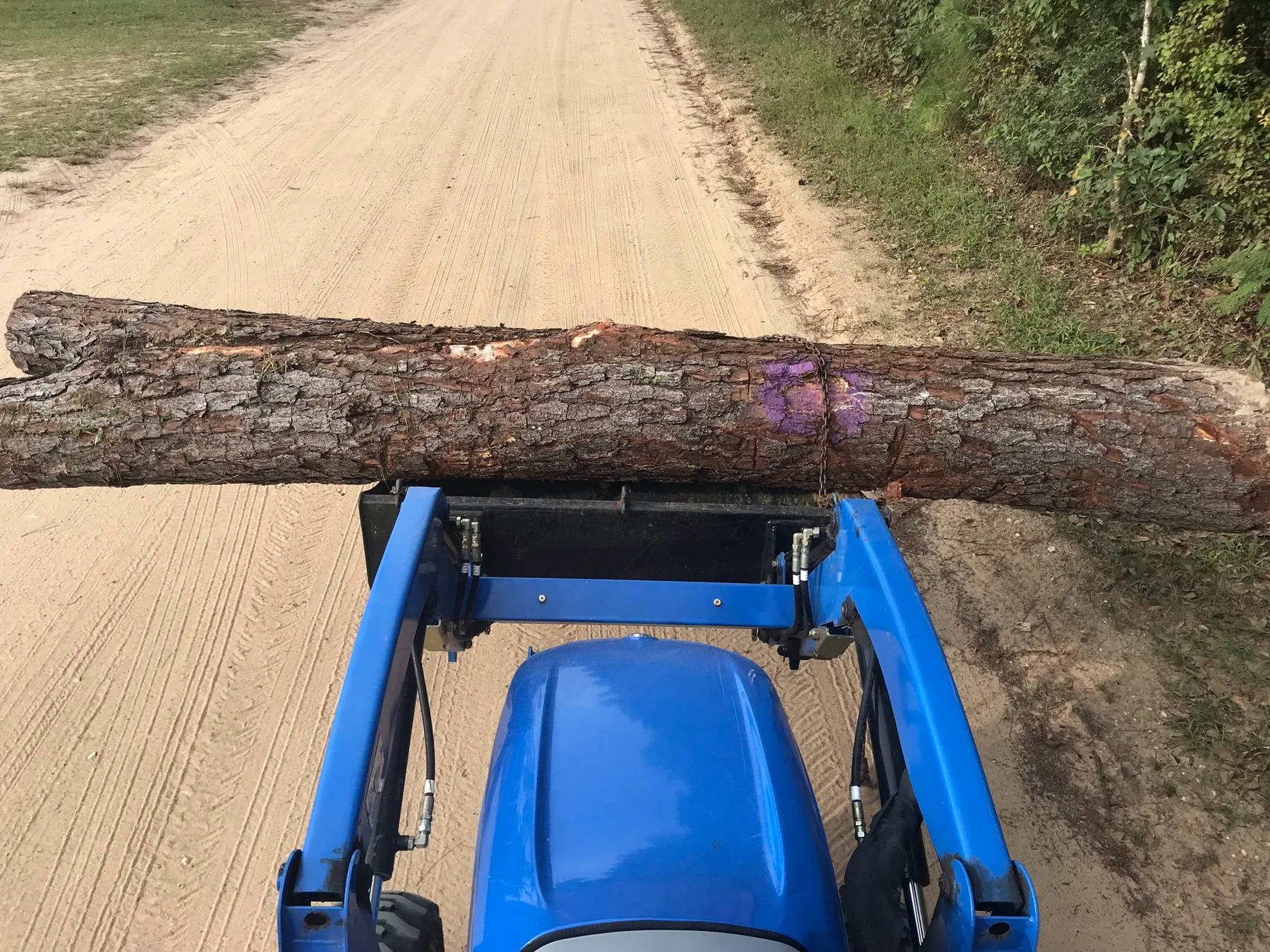 Tractor transporting a large log